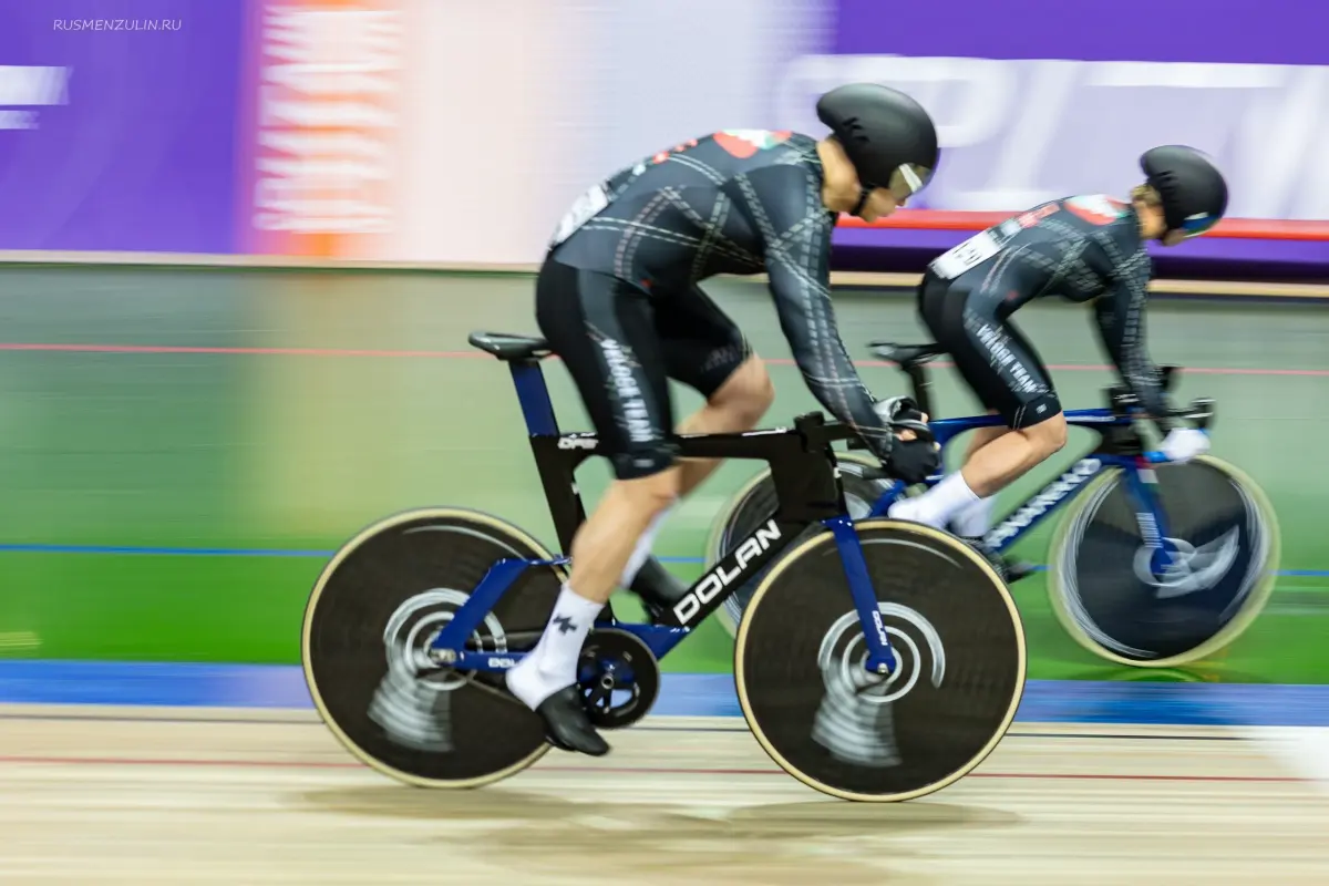 Two CyclingRace cyclists ride on a bike track