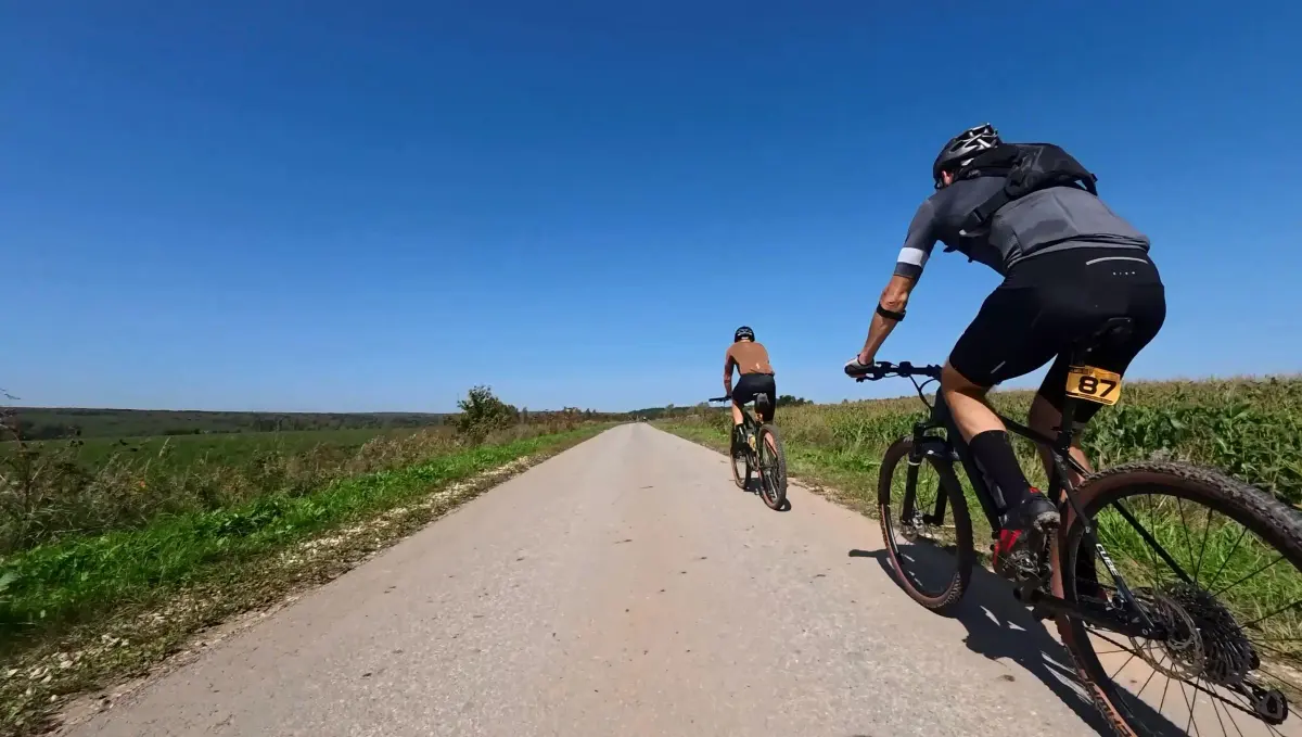 Gravel racer GravelCyclist on the road among the fields