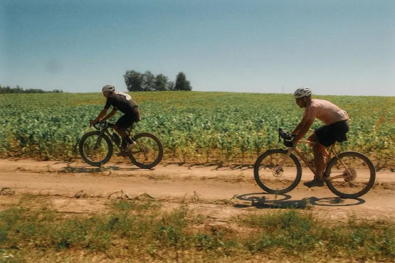 Two Gravel Instinct members are driving along a dirt road among fields