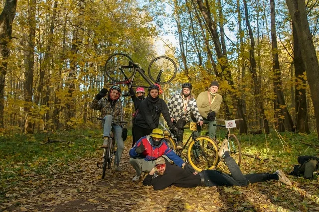 Participants with bicycles in the autumn park after the race