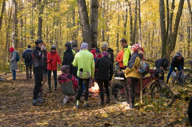 Participants and spectators in the starting town among the autumn trees